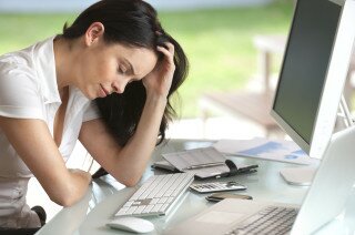 Woman looking stressed at her desk